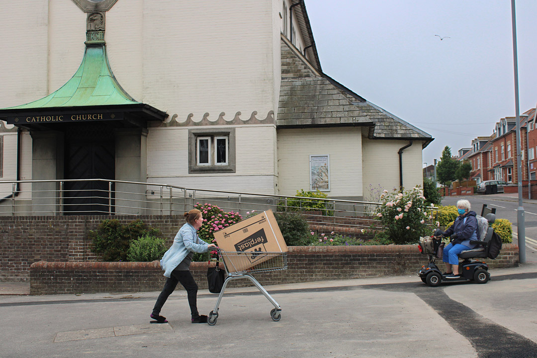 Photo 4, pushing a trolley past a Catholic church in Weymouth